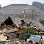 A flag was seen from a hole in a demolished home near a deadly mudslide.